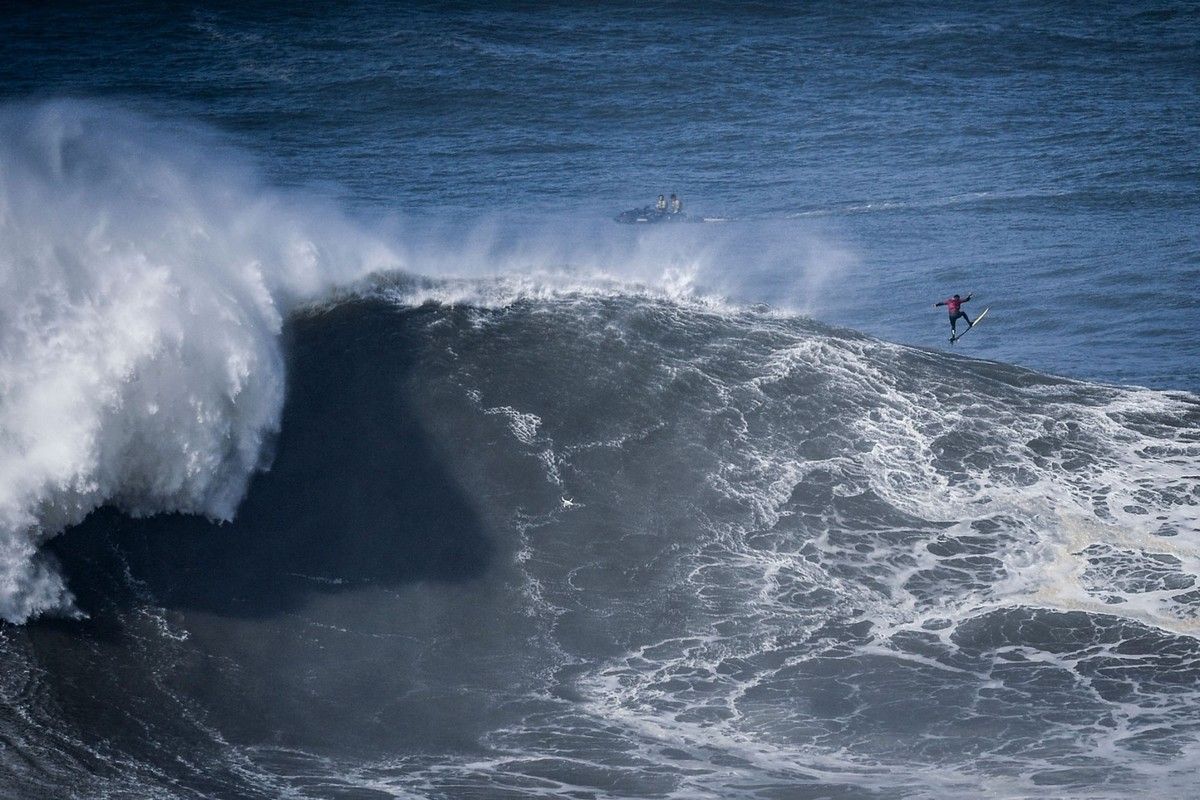 Первыми приходят волны. Назаре Португалия серфинг. Огромные волны Praia do Norte. Мыс Португалия Биг Вейв серфинг. Высокие волны.