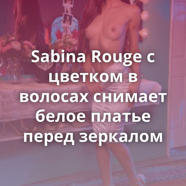 Sabina Rouge с цветком в волосах снимает белое платье перед зеркалом