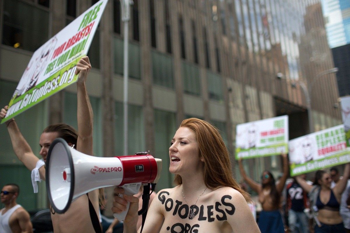 Активисты движения Go Topless обоих полов, сняв верхние части одежды, прошл...